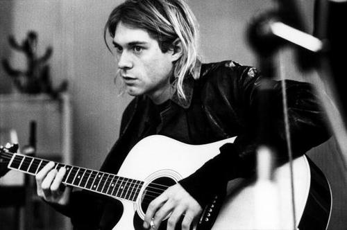 Black and White Photo of Kurt Cobain Holding a Guitar